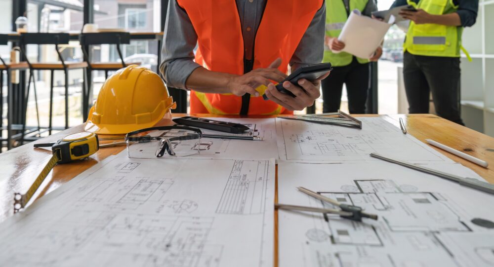 Engineers working on blueprints and construction plans. Building engineers calculate and draft